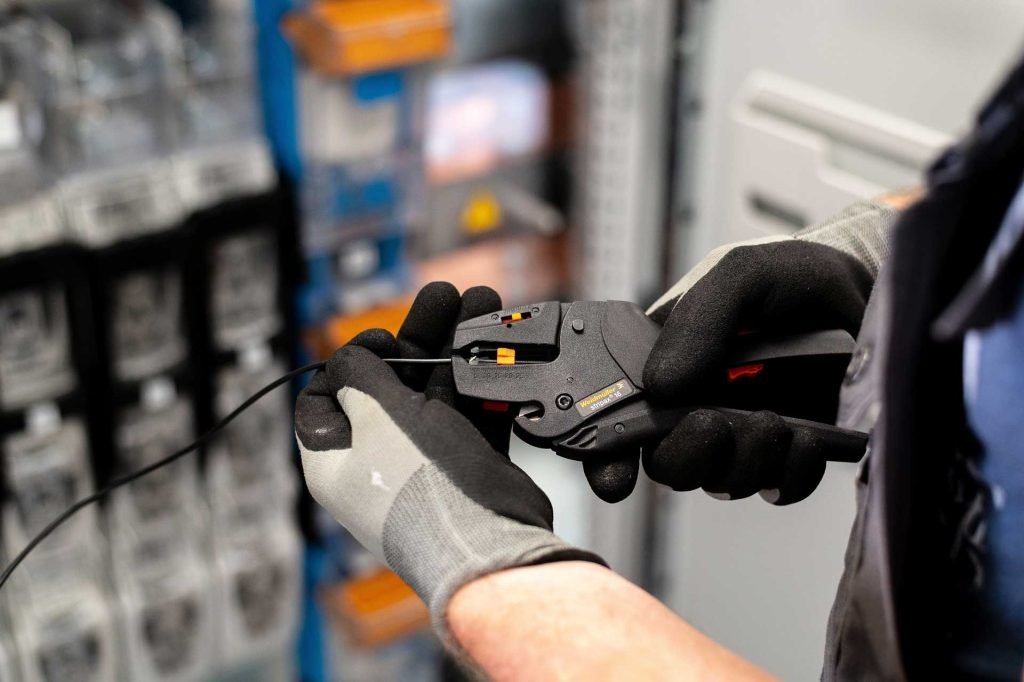 Electricista con guantes reparando una instalación